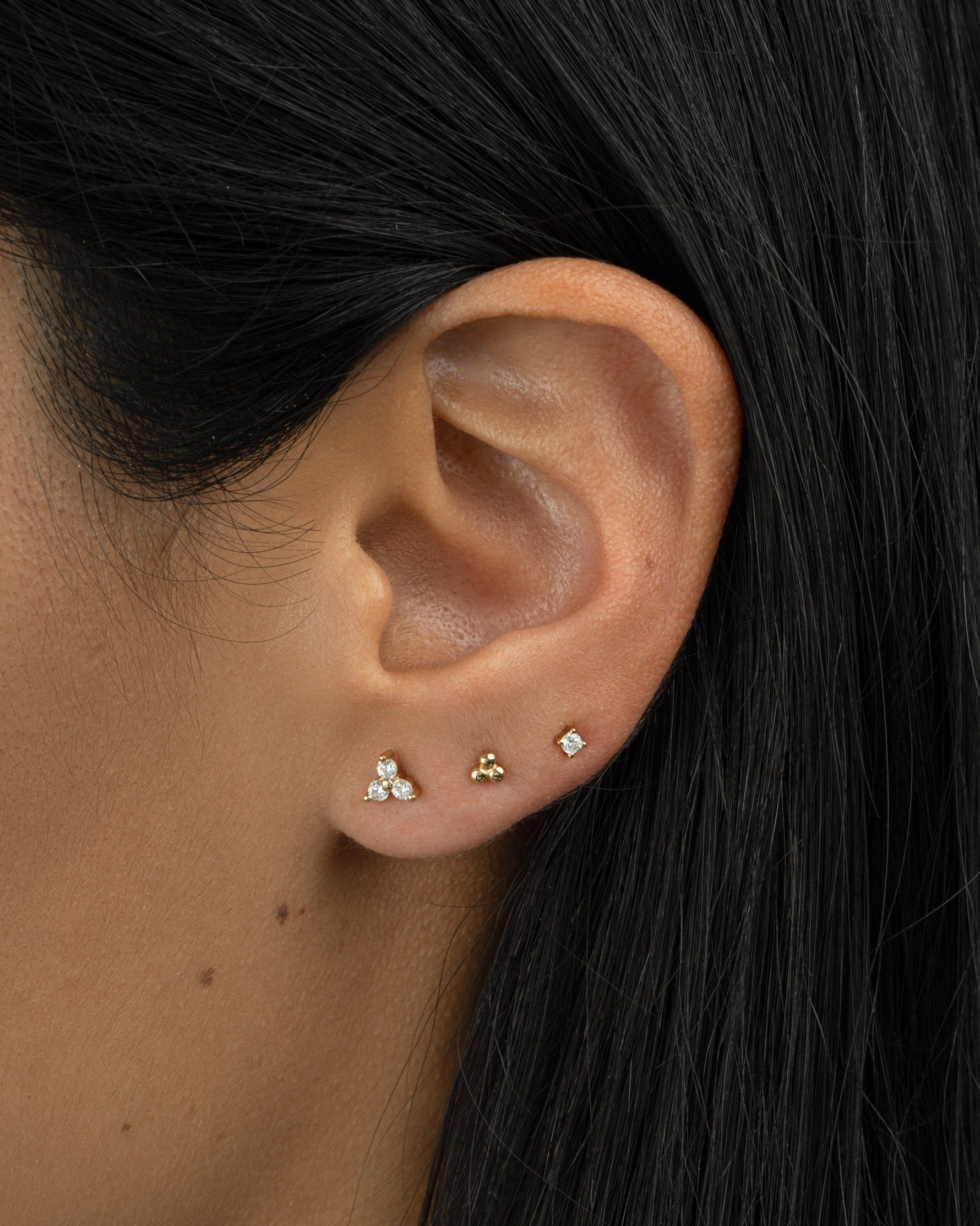 Gold three-stone CZ stud earrings by Sami Jewels, featuring sparkling cubic zirconia stones set in a classic design.