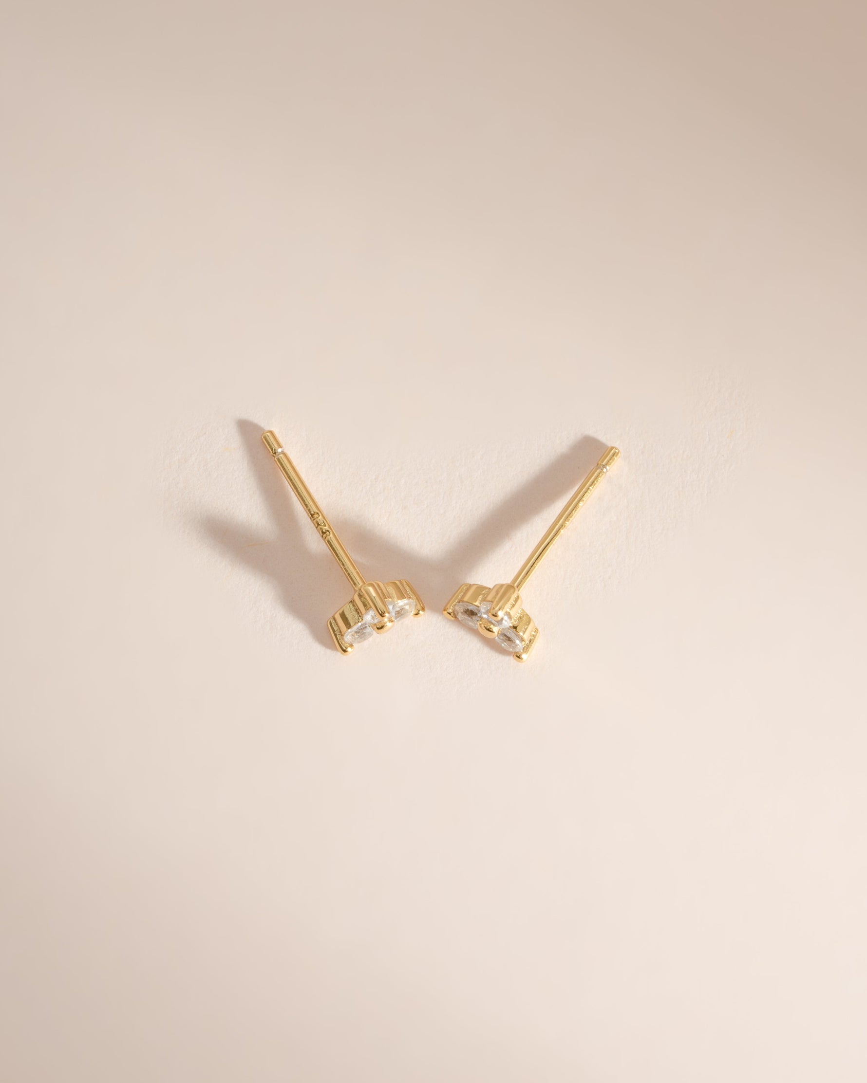 Sami Jewels three-stone cubic zirconia stud earrings with gold setting, top view showing sparkling stones and classic design.