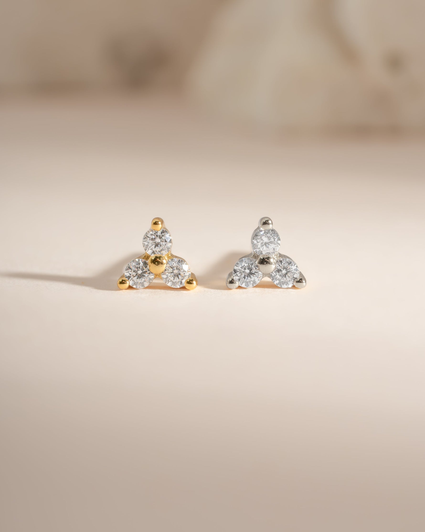 Sterling silver and gold three-stone CZ stud earrings by Sami Jewels, showcasing sparkling cubic zirconia stones.