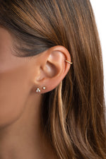 Sami Jewels three-stone cubic zirconia stud earrings in gold, showcasing sparkling gemstone arrangement on the earlobes.