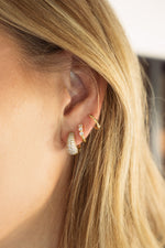 gold three stone huggie earring stacked on models ear