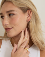 gold three stone huggie earring on model