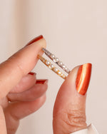 three stone pearl ring in gold and sterling silver held between fingers