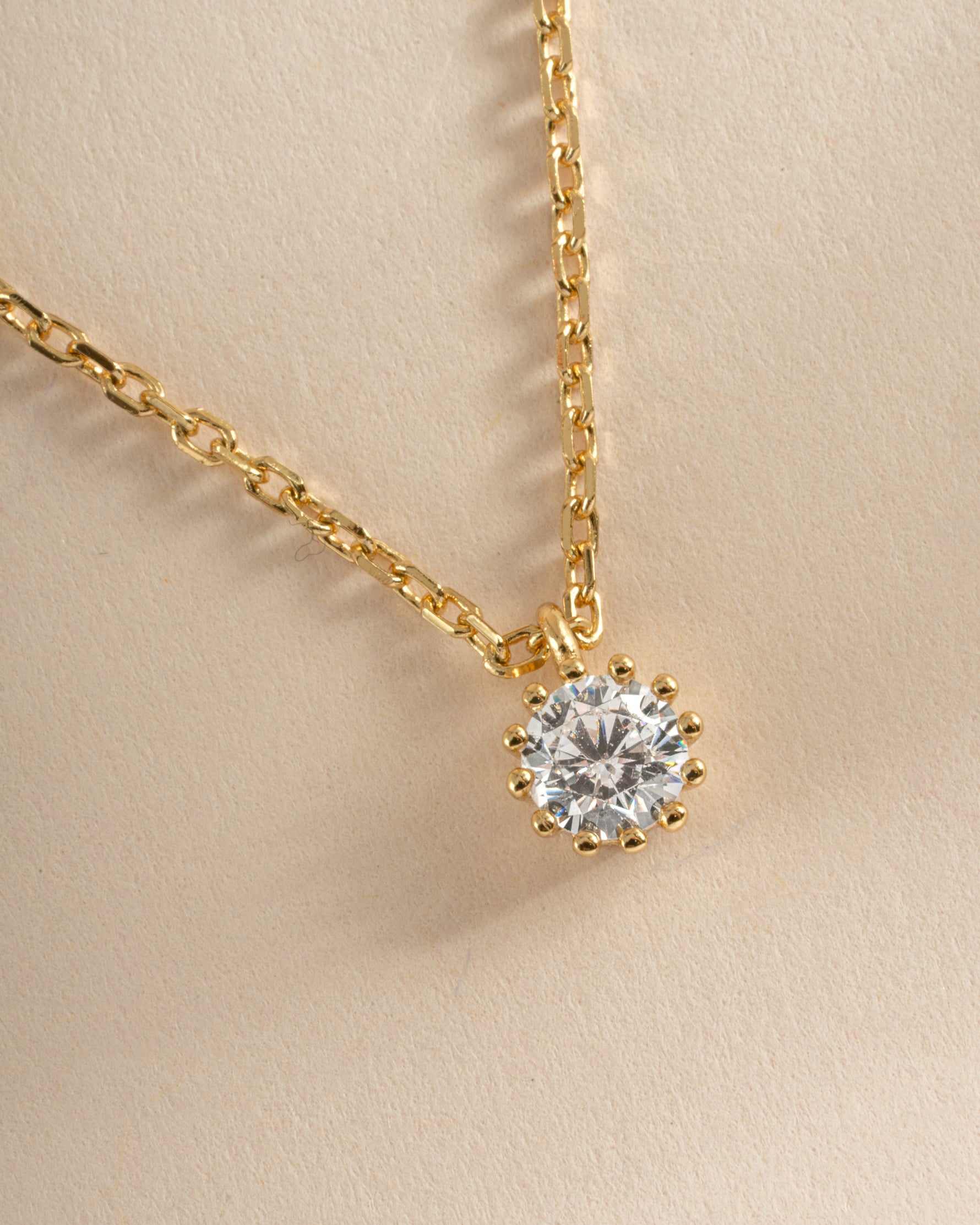 Close-up of Sami Jewels Tiny Bezel Pendant Necklace in gold, showcasing the delicate bezel setting and fine chain.
