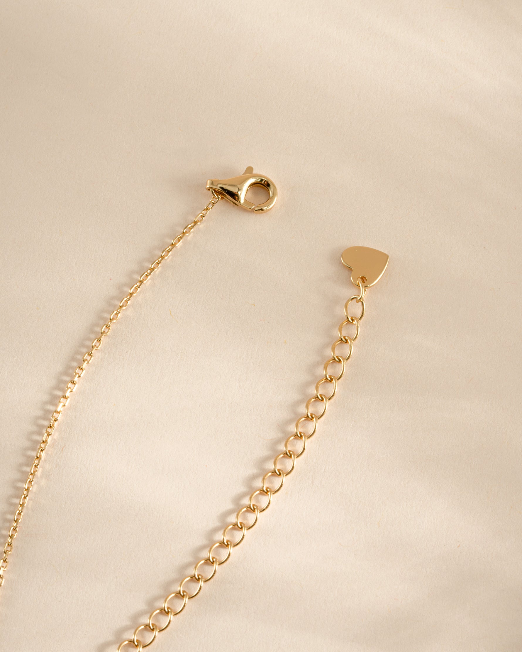 Gold Tiny Bezel Pendant Necklace with lobster clasp by Sami Jewels, close-up view of delicate jewelry on a white background.