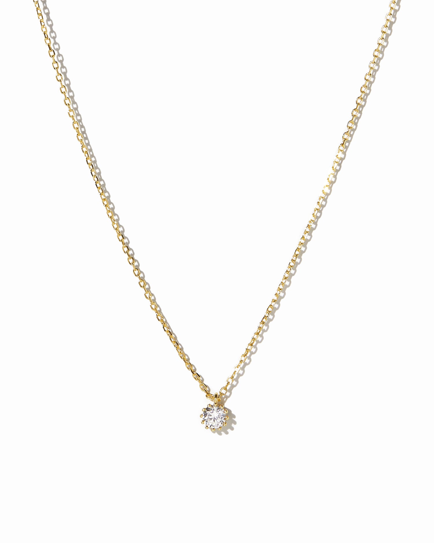 Gold Tiny Bezel Pendant Necklace from Sami Jewels, close-up view showing delicate chain and small bezel pendant on a white background.