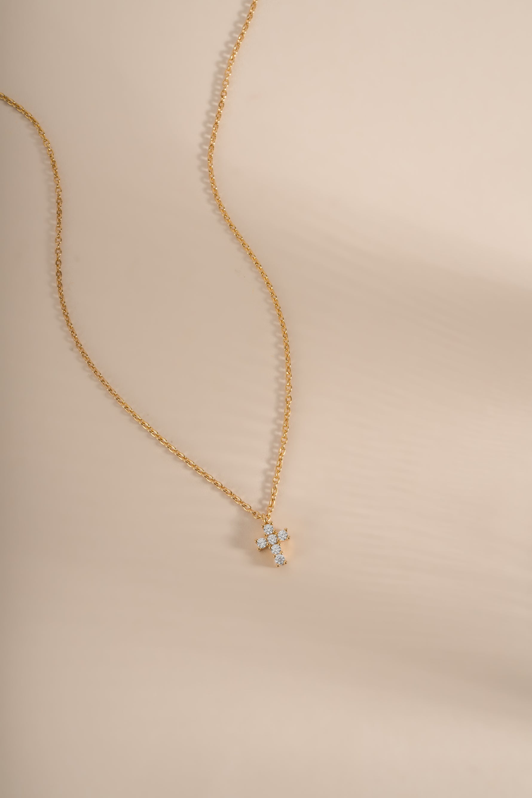 Gold Tiny Cross Necklace from Sami Jewels featuring a delicate cross pendant on a fine chain.