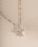 Close-up of a sterling silver Tiny Cross Necklace pendant from Sami Jewels, showing the delicate cross design on a chain.
