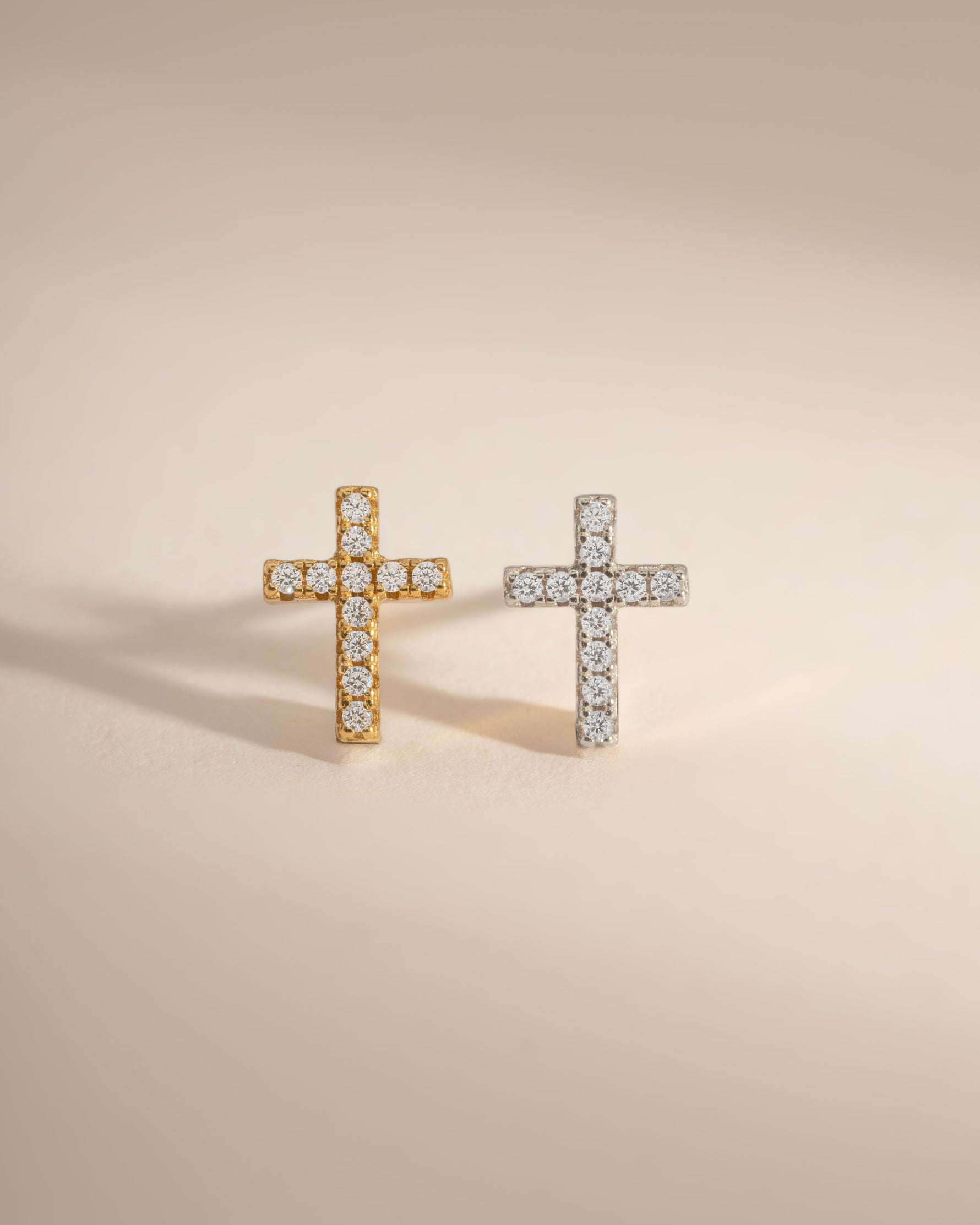 Sterling silver and gold tiny cross stud earrings by Sami Jewels displayed on a white background.