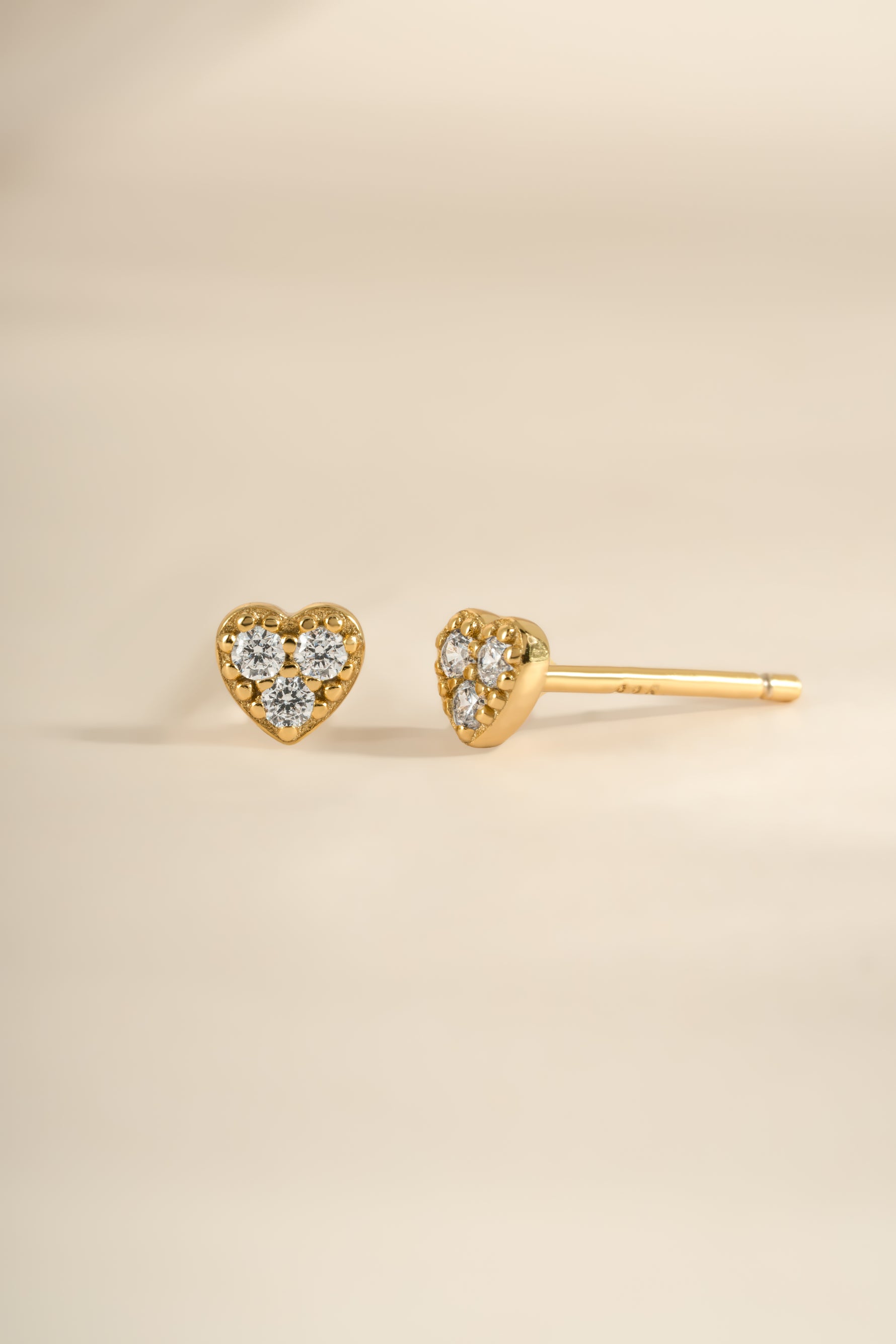 Gold Tiny Heart CZ Stud Earrings by Sami Jewels featuring sparkling cubic zirconia heart charms for a delicate, elegant look.