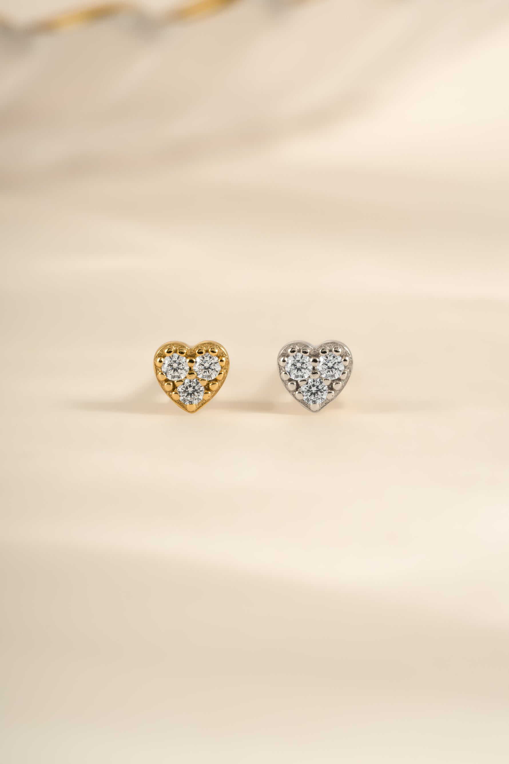 Sterling silver and gold Tiny Heart CZ Stud Earrings by Sami Jewels featuring small sparkling heart-shaped cubic zirconia.