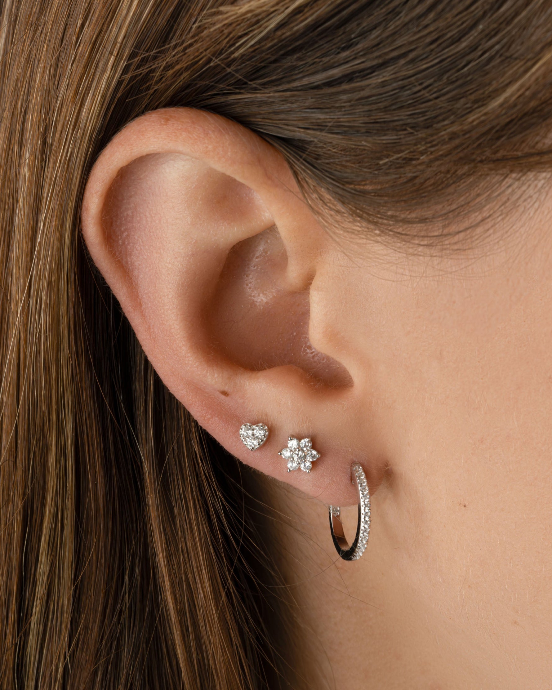 Sami Jewels Tiny Heart CZ Sterling Silver Stud Earrings on a model, featuring small heart-shaped cubic zirconia stones.