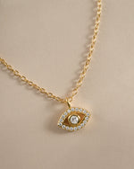 Close-up of Sami Jewels tiny gold evil eye necklace showcasing delicate design and detailed charm.