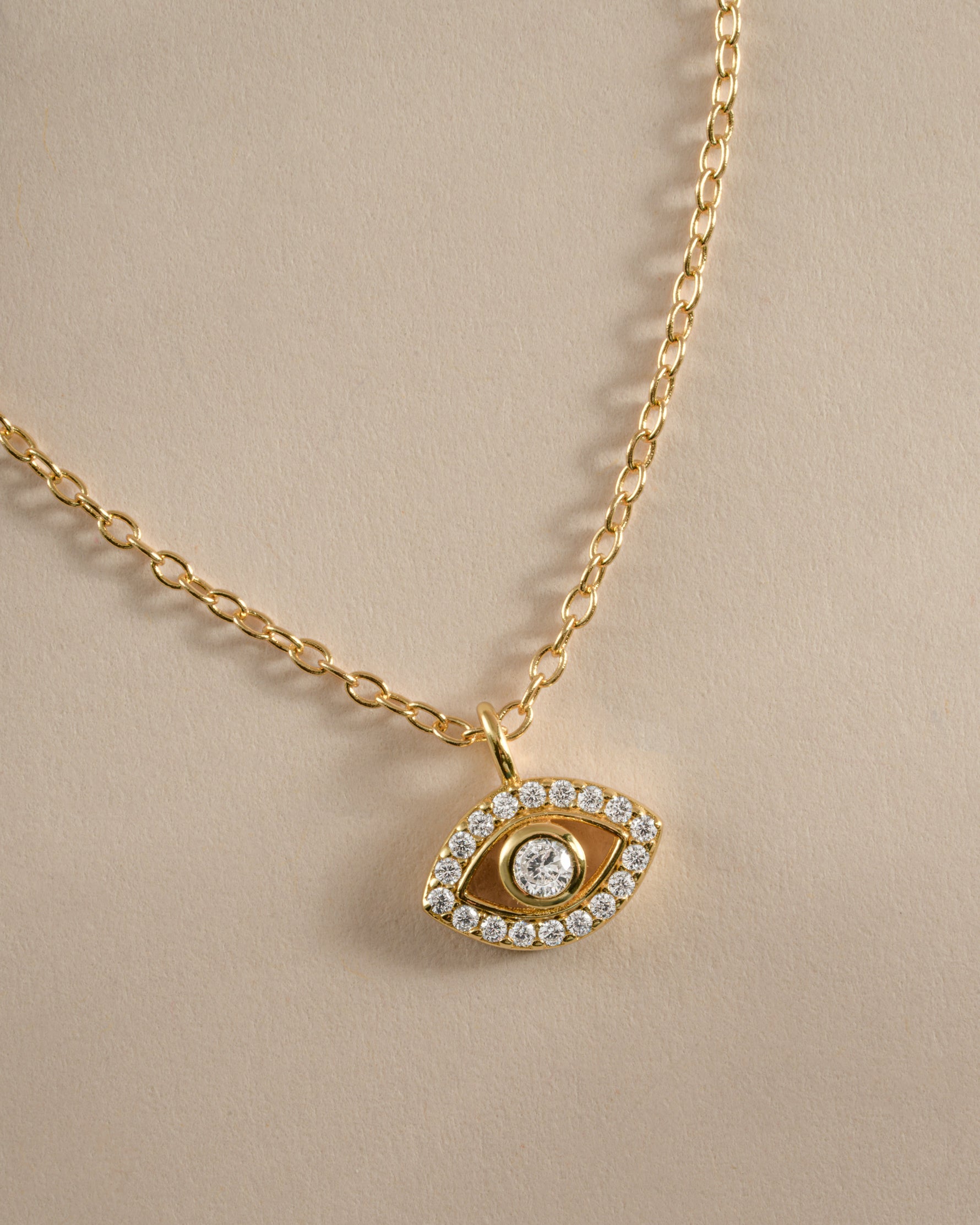 Close-up of Sami Jewels tiny gold evil eye necklace showcasing delicate design and detailed charm.
