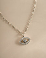Close-up of Sami Jewels tiny evil eye necklace in sterling silver, showcasing a delicate pendant with intricate detailing.
