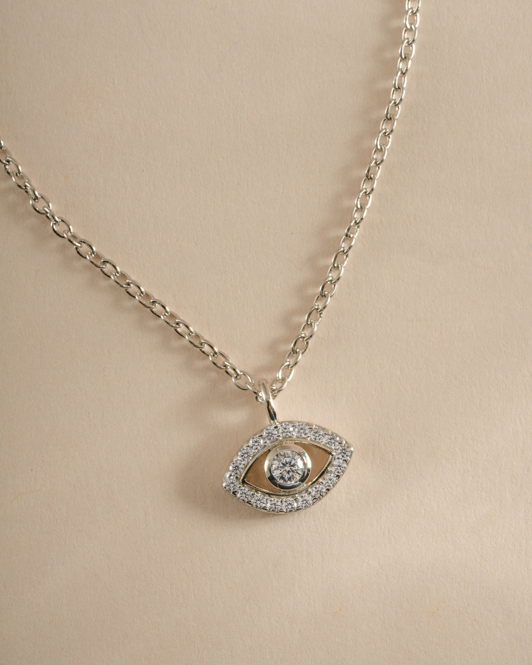 Close-up of Sami Jewels tiny evil eye necklace in sterling silver, showcasing a delicate pendant with intricate detailing.