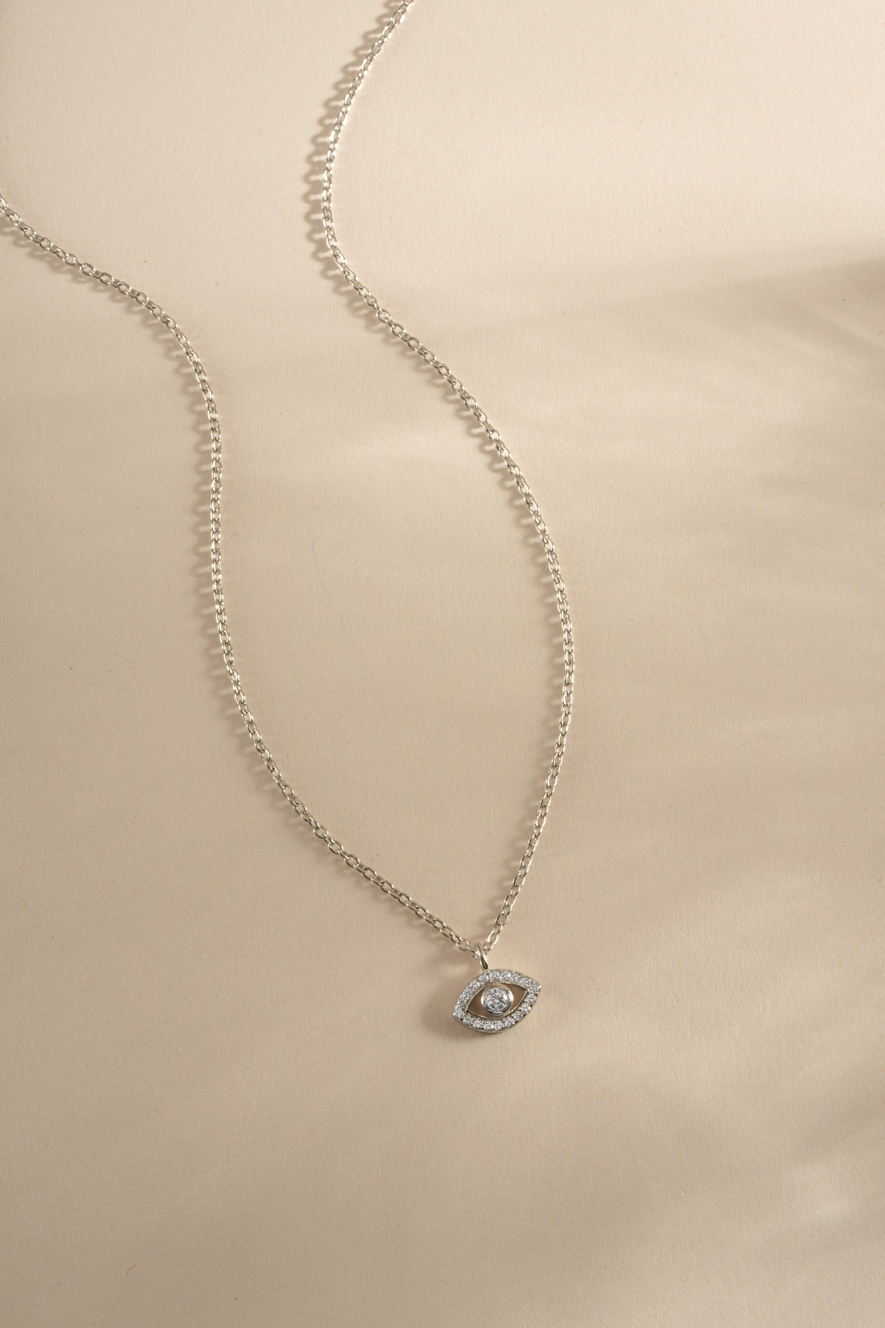 Sterling silver tiny evil eye necklace from Sami Jewels, featuring a delicate charm on a fine chain.