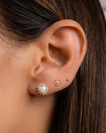 Gold tiny flower stud earrings by Sami Jewels featuring delicate floral design on a model.