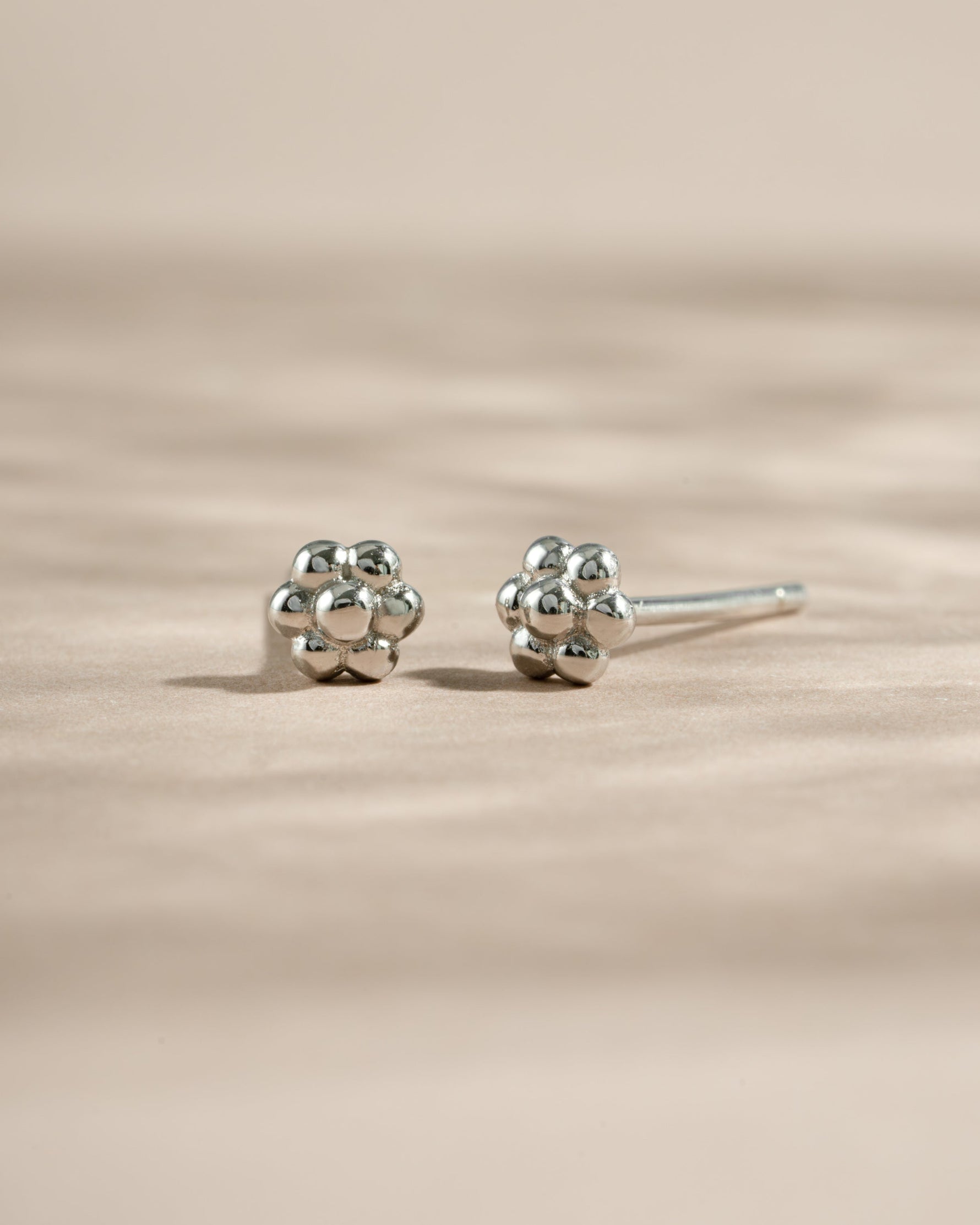 Sterling silver tiny flower stud earrings by Sami Jewels, featuring delicate floral design perfect for everyday wear.