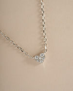 Close-up of Sami Jewels sterling silver Tiny Heart Necklace showing a delicate heart pendant on a fine chain.