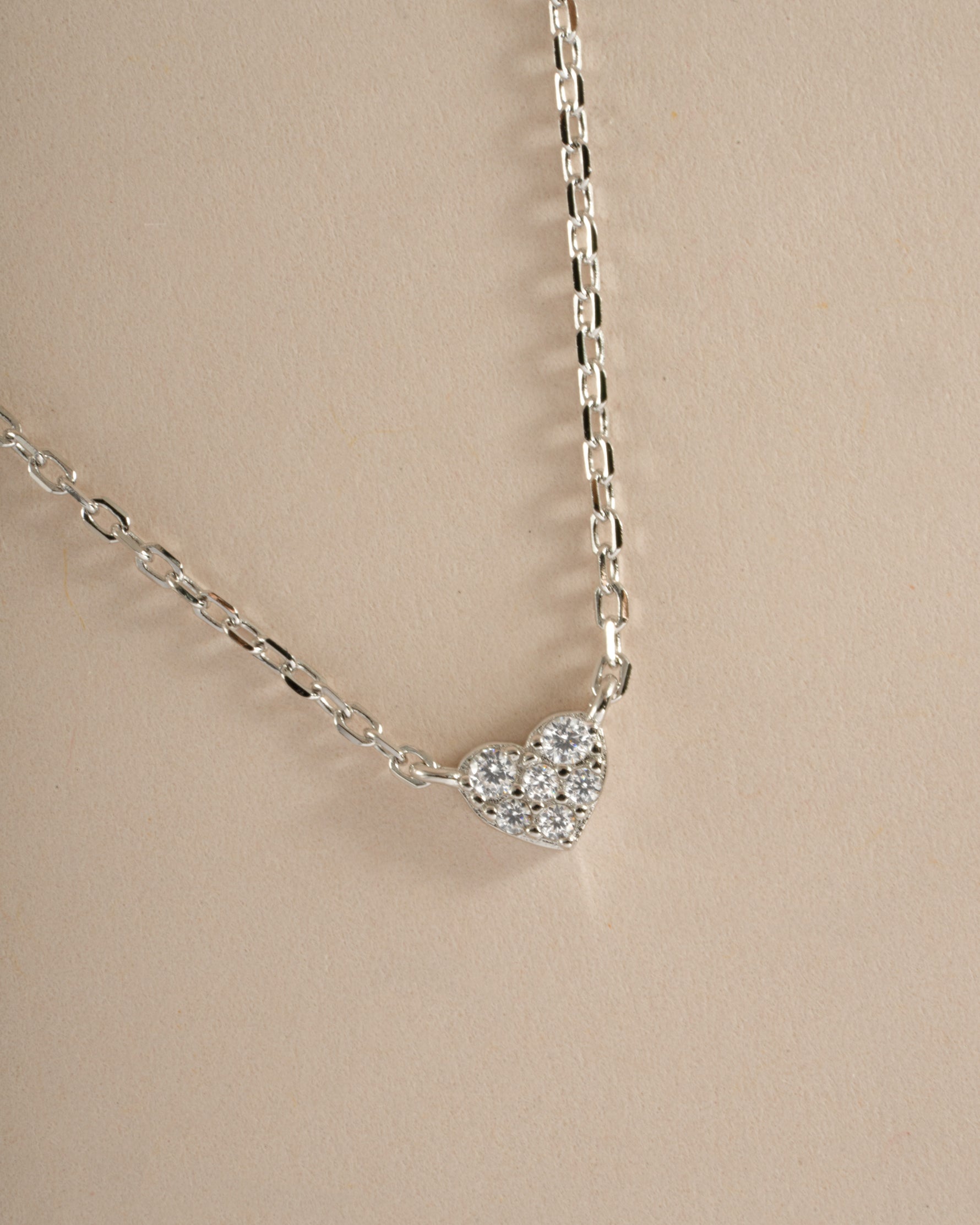 Close-up of Sami Jewels sterling silver Tiny Heart Necklace showing a delicate heart pendant on a fine chain.