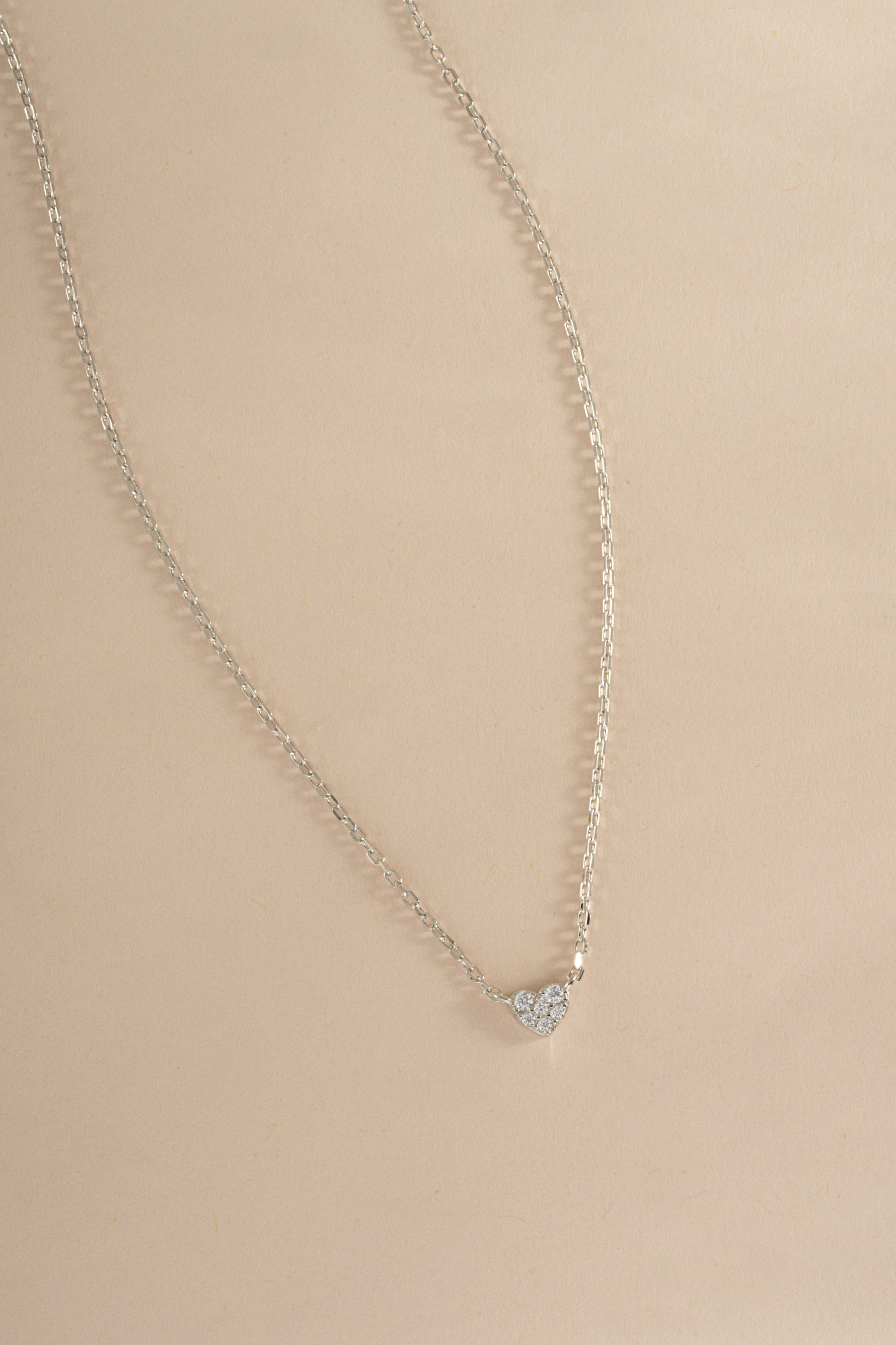 Sterling silver Tiny Heart Necklace from Sami Jewels showing a delicate heart pendant on a chain.