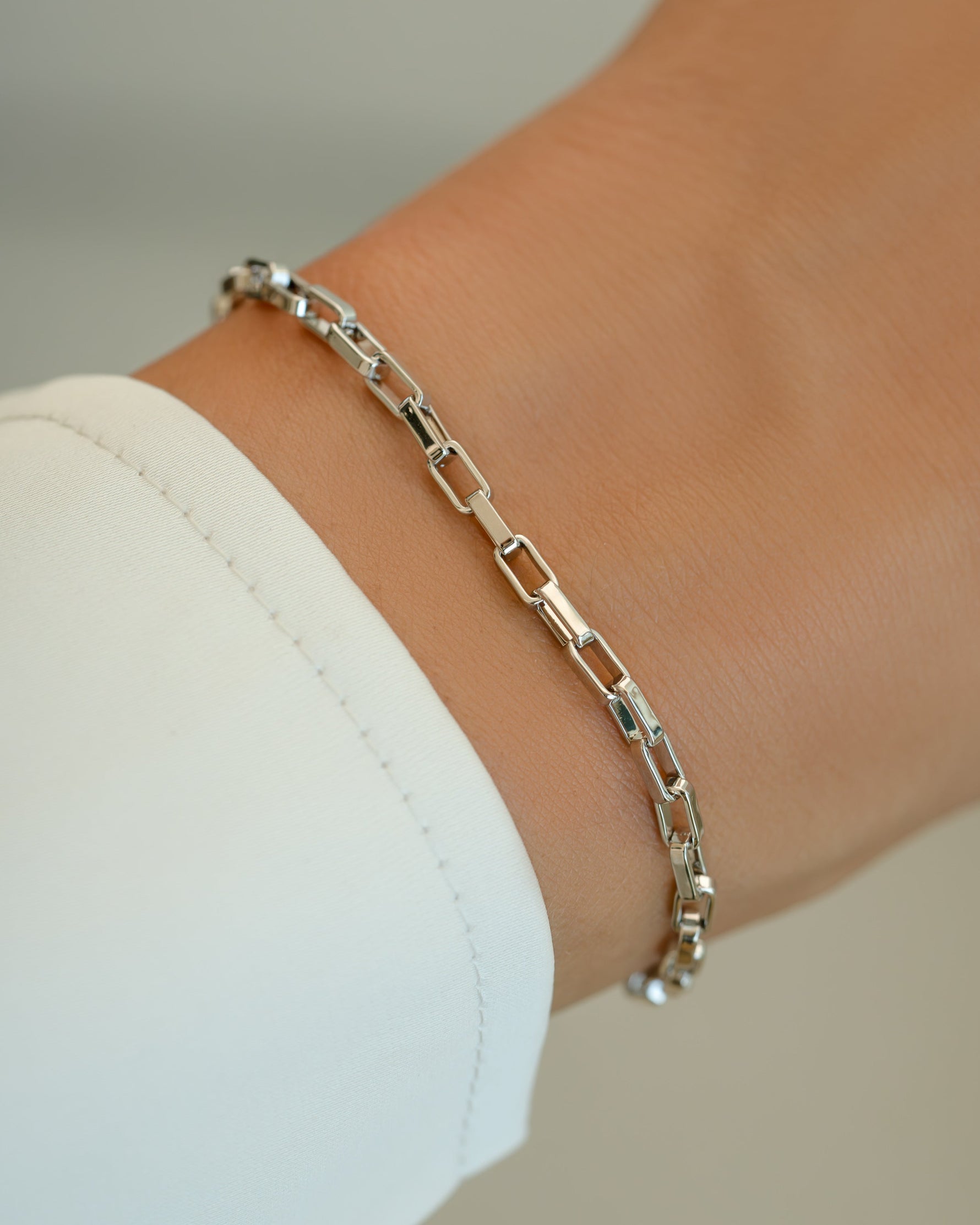 Silver Tiny Link Paperclip Bracelet by Sami Jewels featuring sleek, minimalist chain links on a model's wrist.