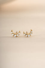 Gold tiny moon stud earrings from Sami Jewels with a close-up angled view, showcasing their small, celestial design.