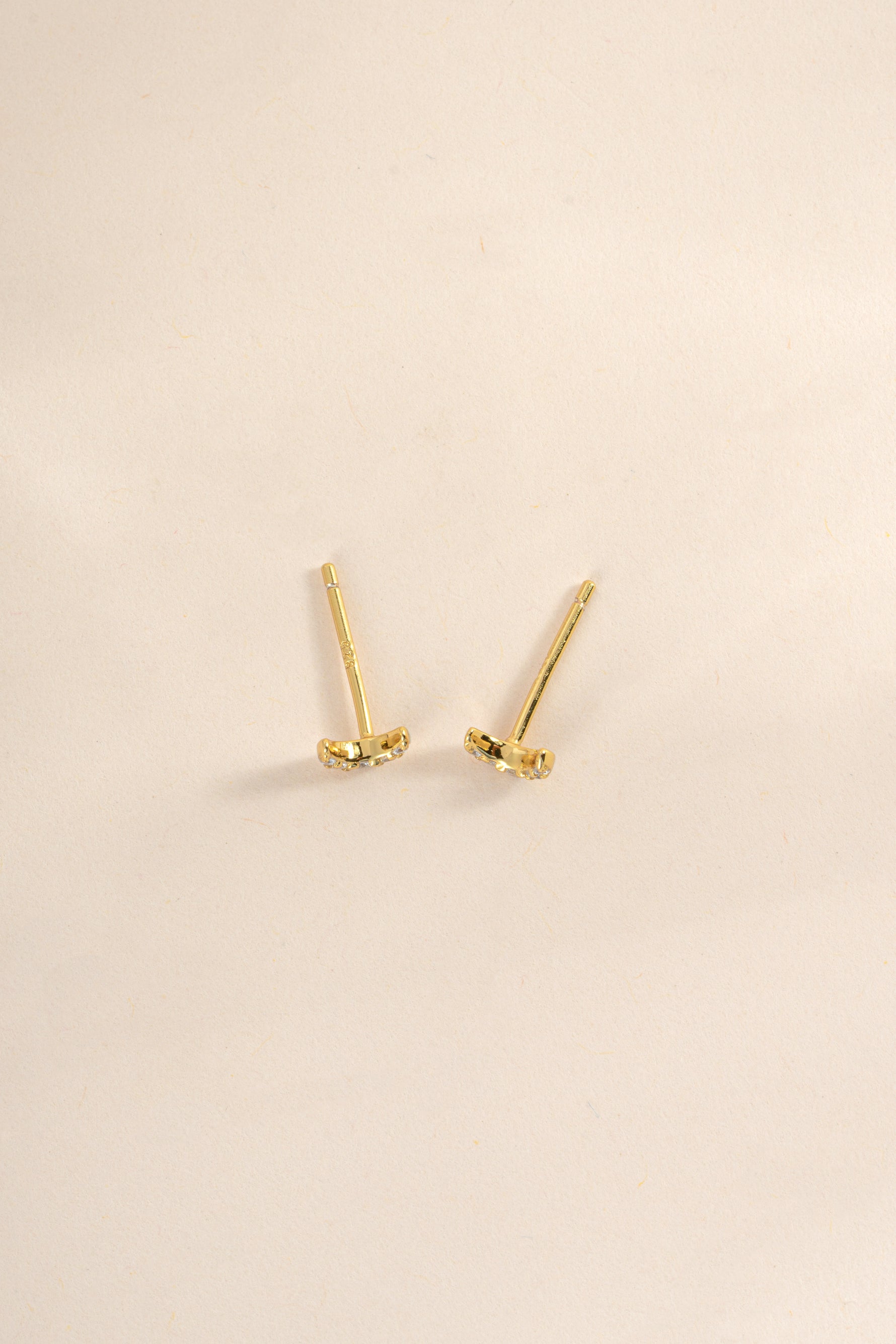 Gold tiny moon stud earrings by Sami Jewels, top view showing small moon-shaped design on each earring