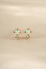 Gold tiny opal stud earrings by Sami Jewels, front view showing small oval-shaped opal gemstones in a classic earring setting.