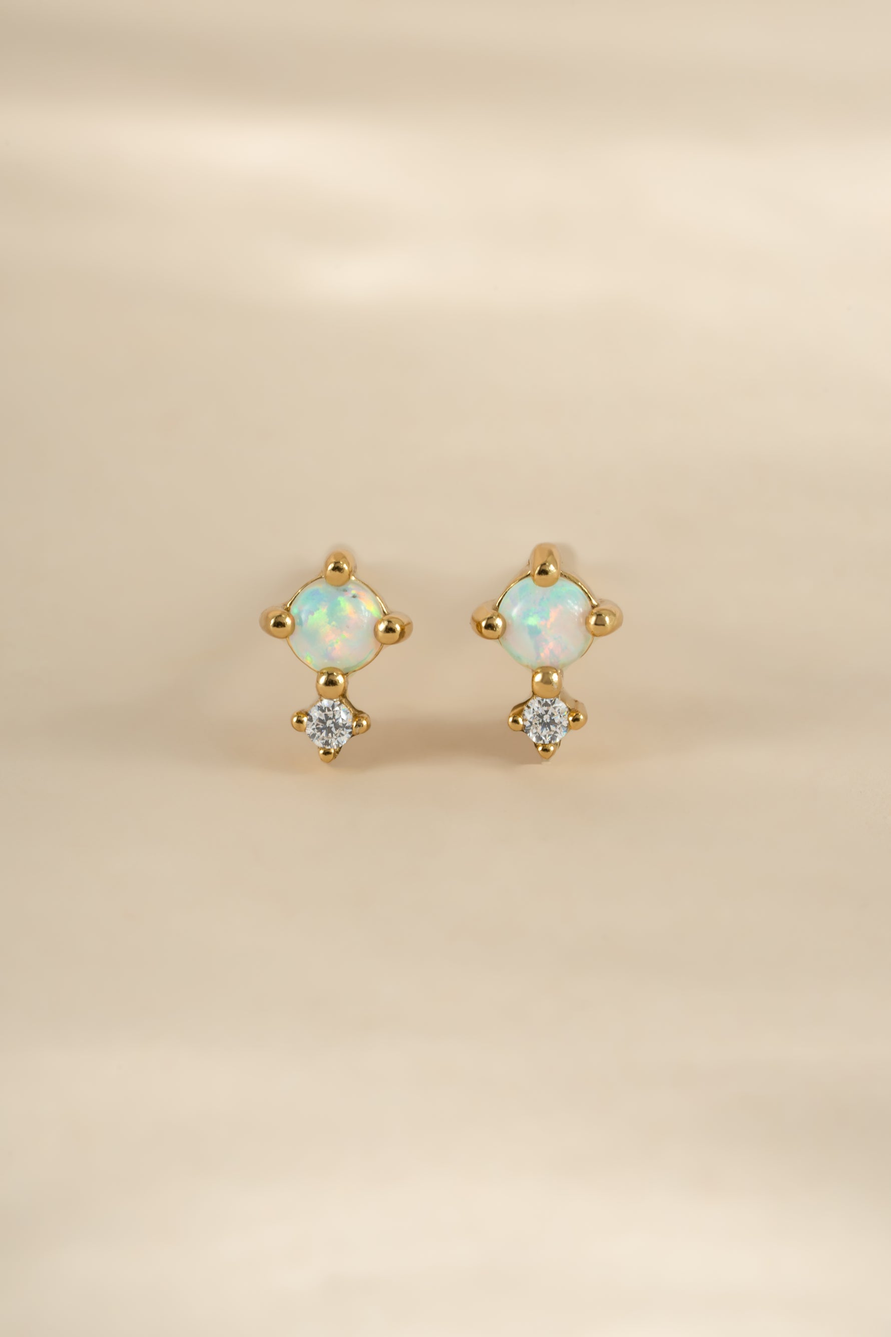Gold tiny opal stud earrings by Sami Jewels, front view showing small oval-shaped opal gemstones in a classic earring setting.