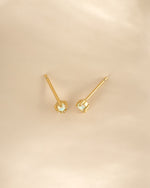 Gold tiny opal stud earrings from Sami Jewels, close-up view showcasing the small, iridescent opal gemstones on delicate earring posts.