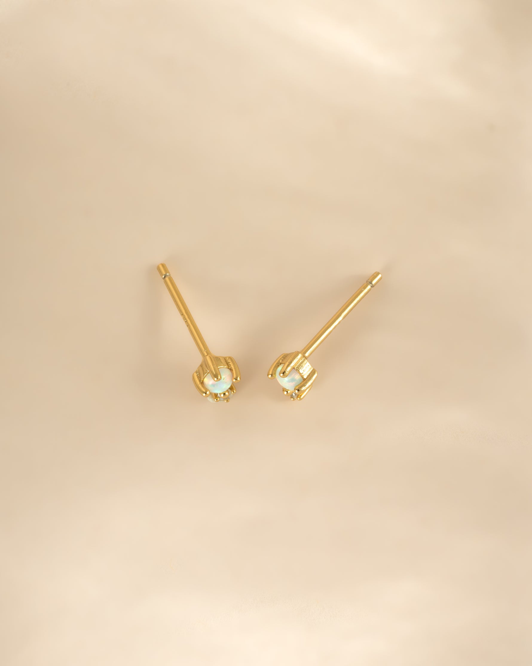 Gold tiny opal stud earrings from Sami Jewels, close-up view showcasing the small, iridescent opal gemstones on delicate earring posts.