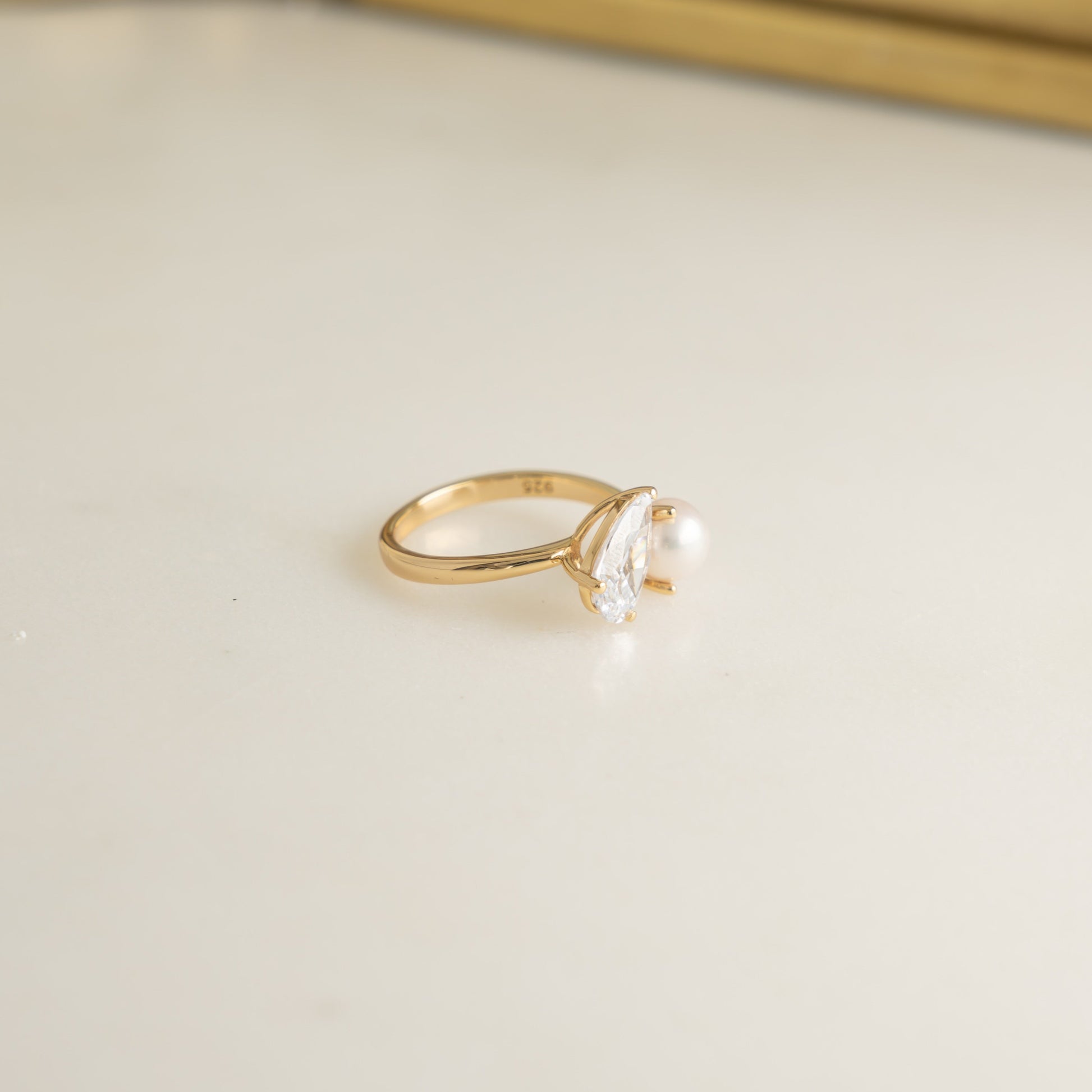 Toi et Moi Ring in a side profile, with the gold setting showing intricate diamond and pearl detail making this ring a standout choice for an engagement ring or a gift for her.