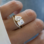 closeup of model wearing a toi et moi ring with a dainty gold curved band