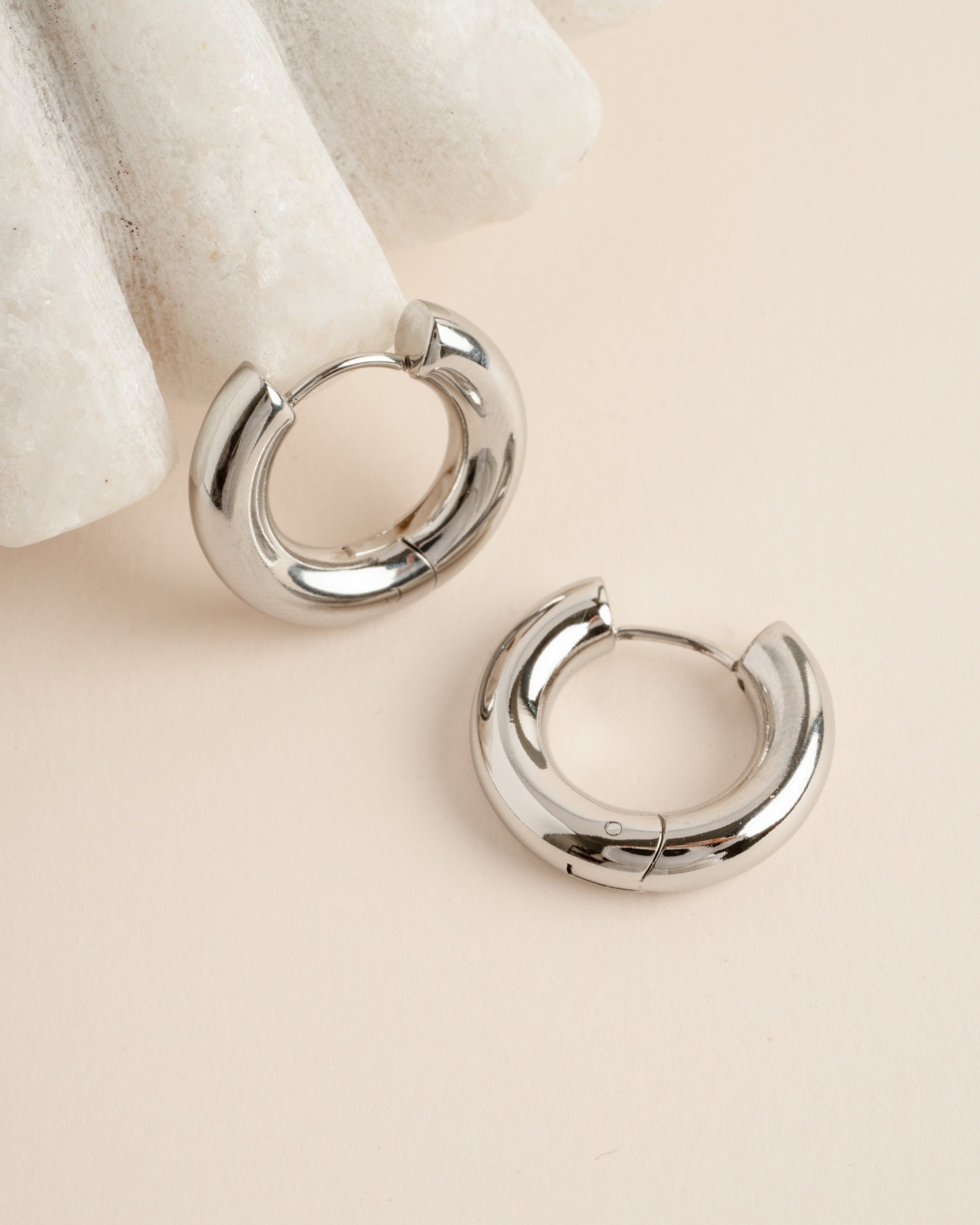 Close-up of silver stainless steel SS Thick Tube Hoop Earrings by Sami Jewels, showcasing their shiny, waterproof design.