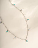 Close-up of Sami Jewels turquoise and CZ dangling charm necklace in sterling silver, showcasing intricate design and vibrant stones.