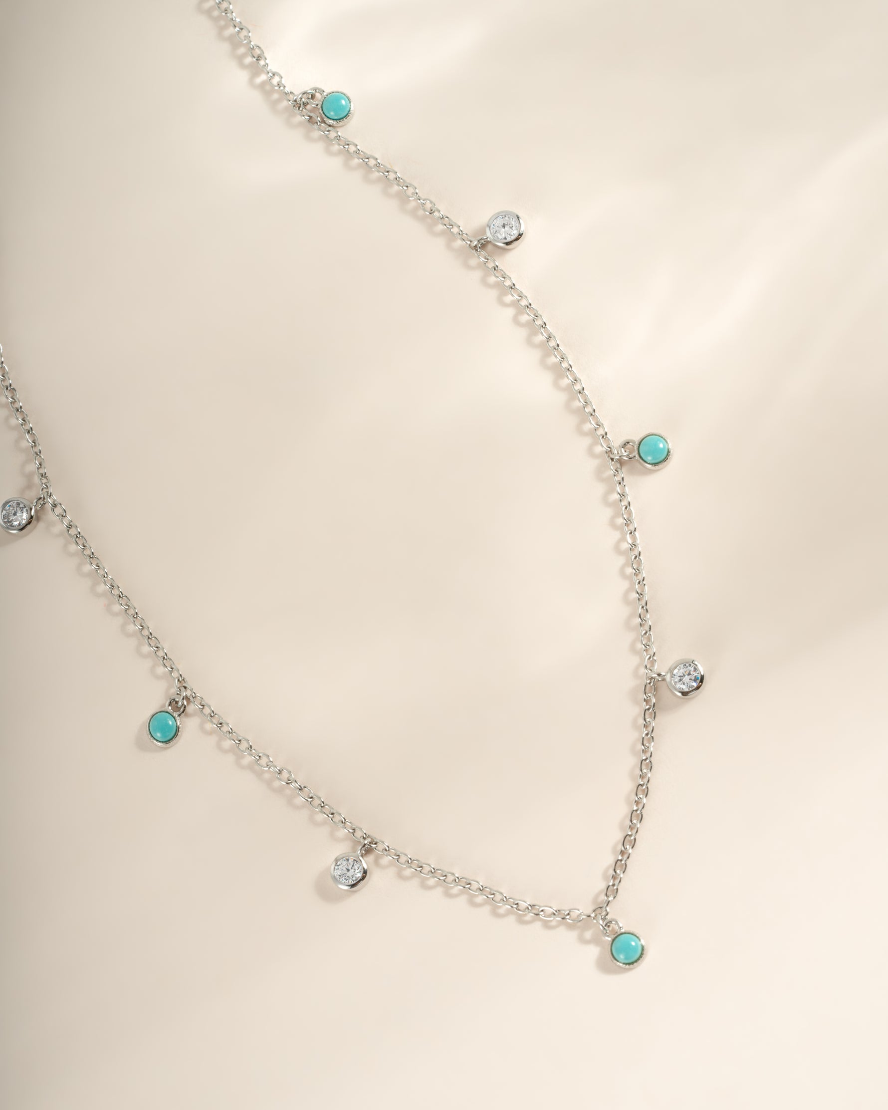 Close-up of Sami Jewels turquoise and CZ dangling charm necklace in sterling silver, showcasing intricate design and vibrant stones.