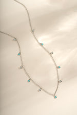Turquoise and CZ dangling charm necklace in sterling silver by Sami Jewels, featuring vibrant turquoise stones and sparkling cubic zirconia.