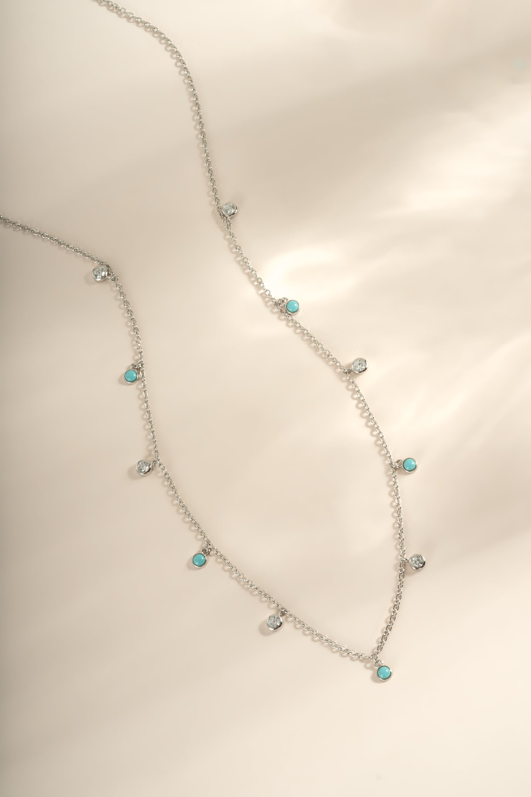 Turquoise and CZ dangling charm necklace in sterling silver by Sami Jewels, featuring vibrant turquoise stones and sparkling cubic zirconia.