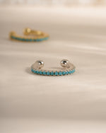 Turquoise ear cuff earrings by Sami Jewels, sterling silver with vibrant turquoise stone, front-facing view showing intricate design.