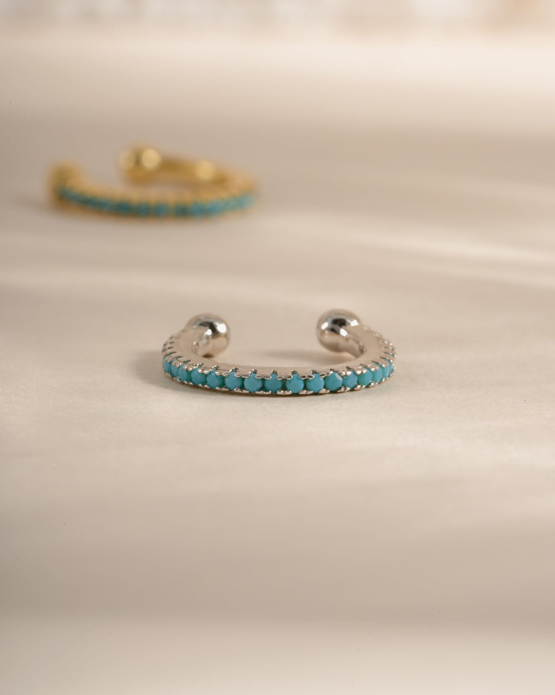 Turquoise ear cuff earrings by Sami Jewels, sterling silver with vibrant turquoise stone, front-facing view showing intricate design.