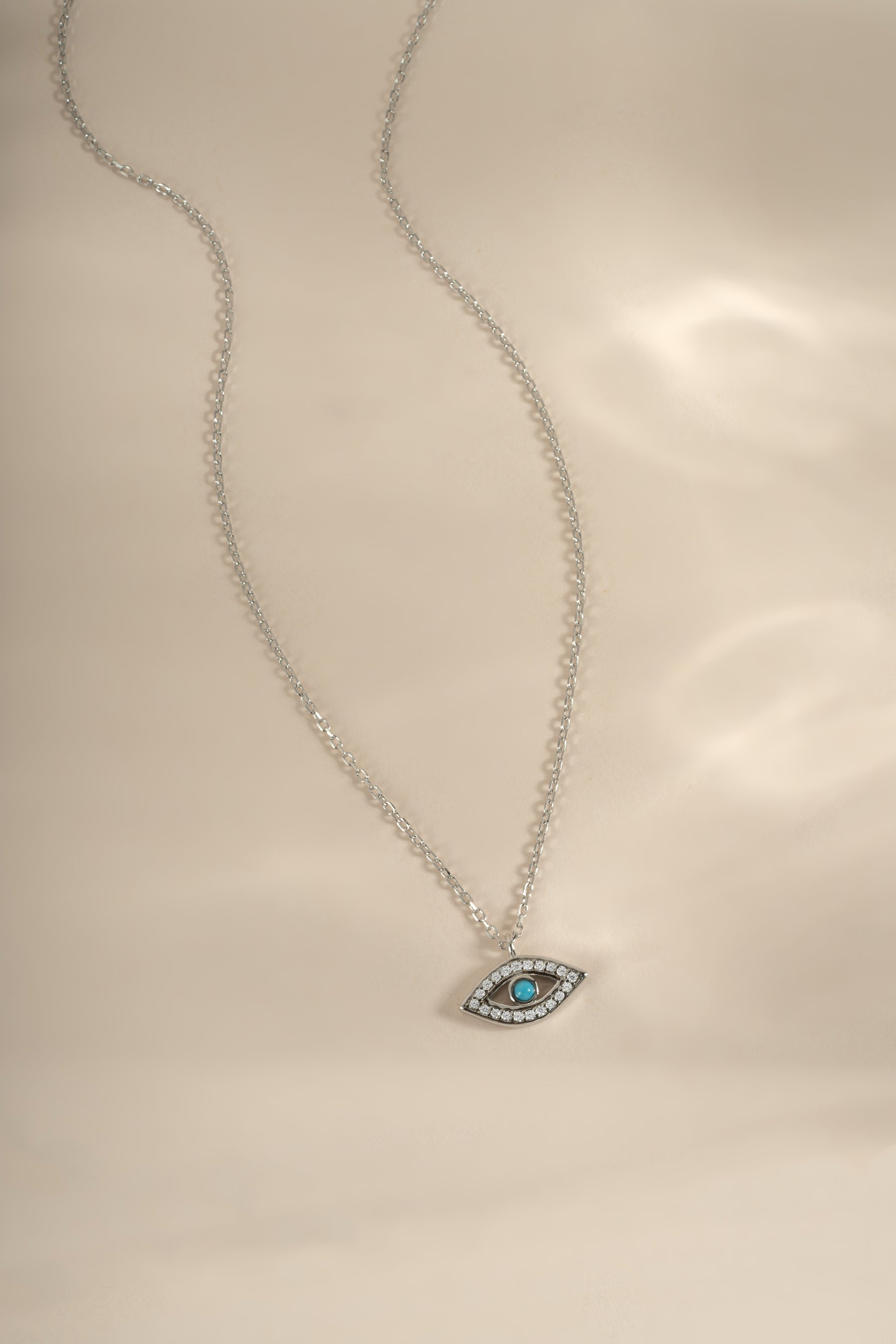 Turquoise evil eye necklace with sterling silver chain from Sami Jewels, featuring a vibrant turquoise pendant with evil eye design.