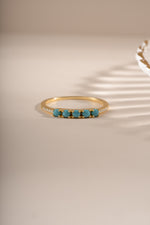Gold 5-stone turquoise ring by Sami Jewels featuring a row of vibrant turquoise stones in a sleek gold setting.