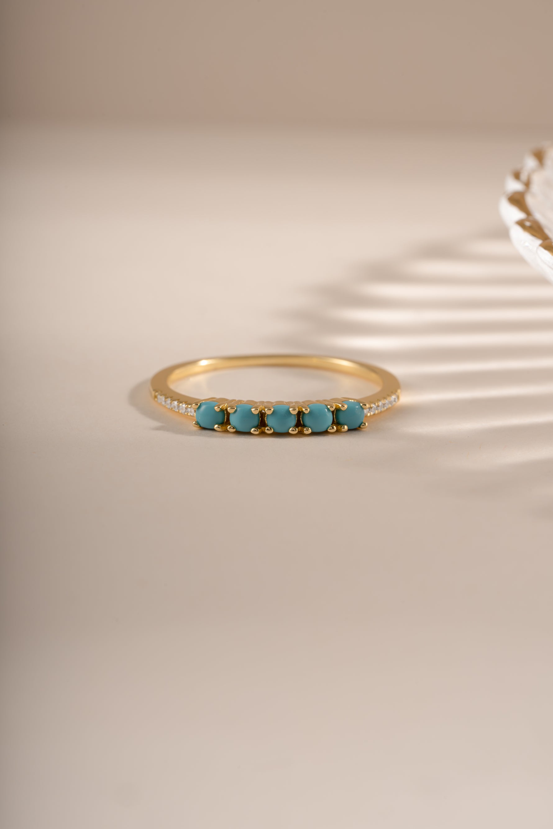 Gold 5-stone turquoise ring by Sami Jewels featuring a row of vibrant turquoise stones in a sleek gold setting.