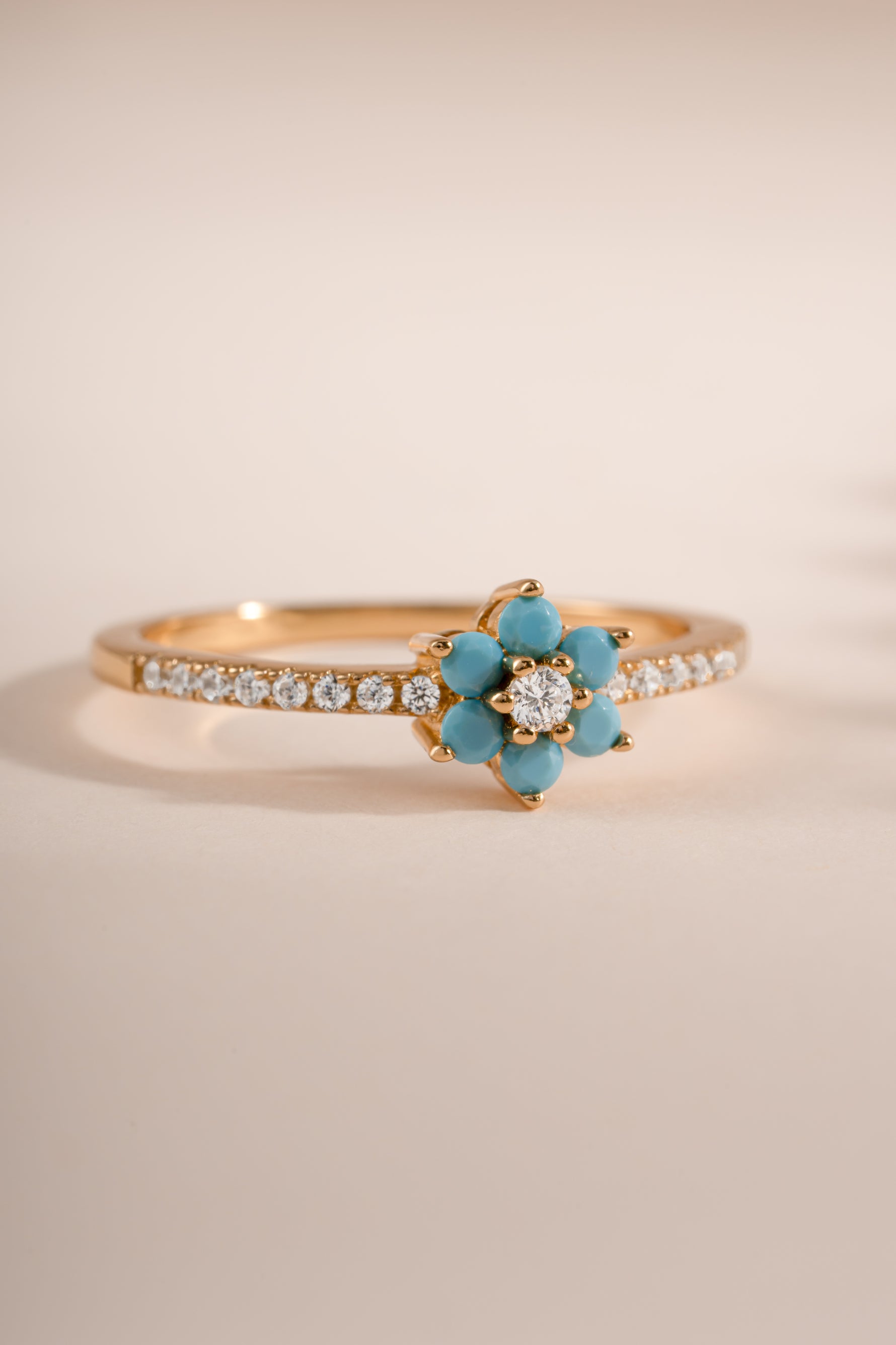 Close-up of Sami Jewels turquoise flower ring showcasing detailed gold band and vibrant turquoise flower design.