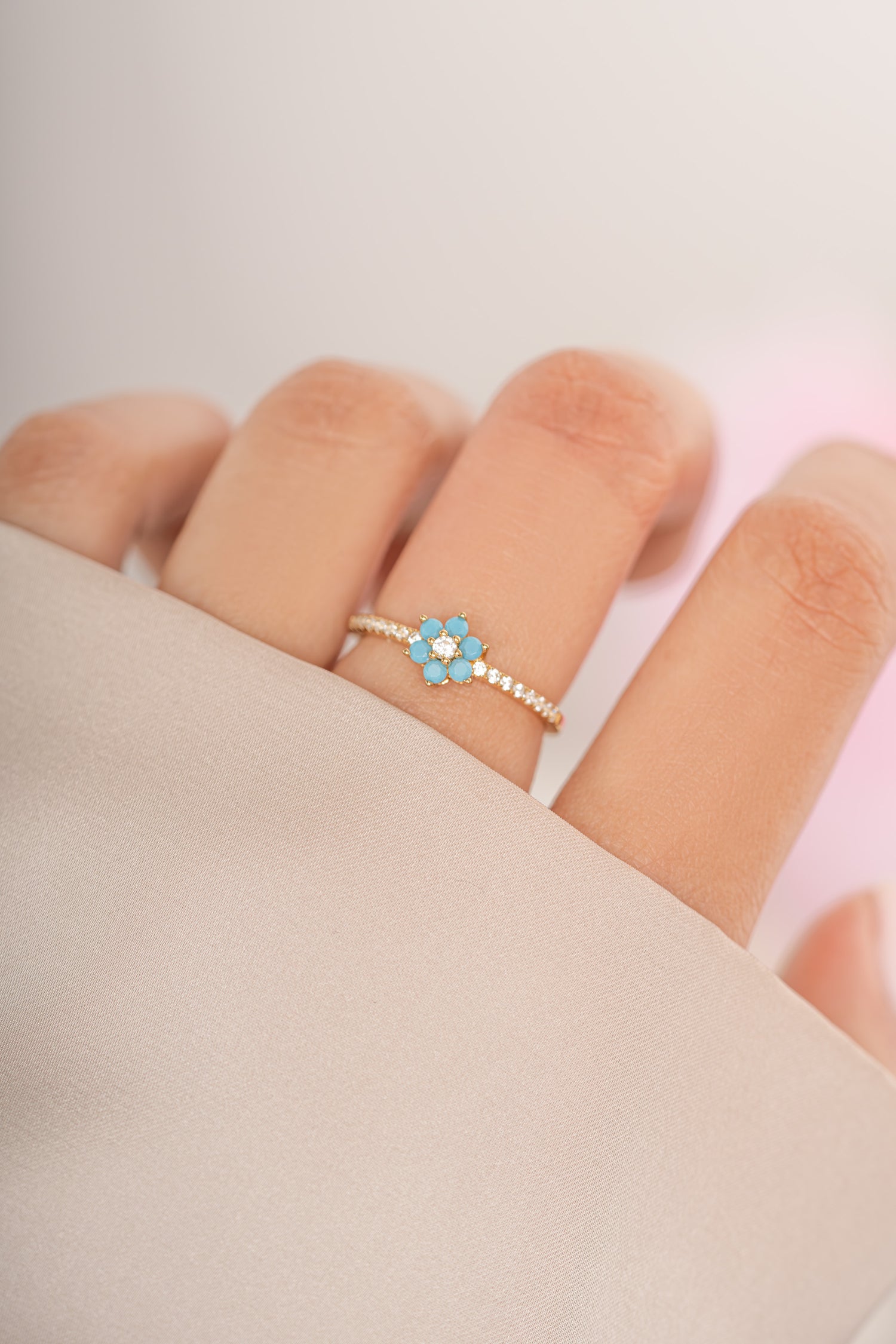 Gold Sami Jewels turquoise flower ring featuring a vibrant turquoise stone and intricate floral design on a model's finger.