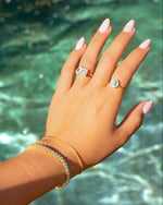 Sami Jewels Layla turquoise halo ring with gold band, featuring a central turquoise gemstone and intricate gold detailing.