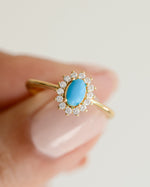 Close-up of Sami Jewels Layla Turquoise Ring featuring an oval turquoise gemstone with a gold halo setting.