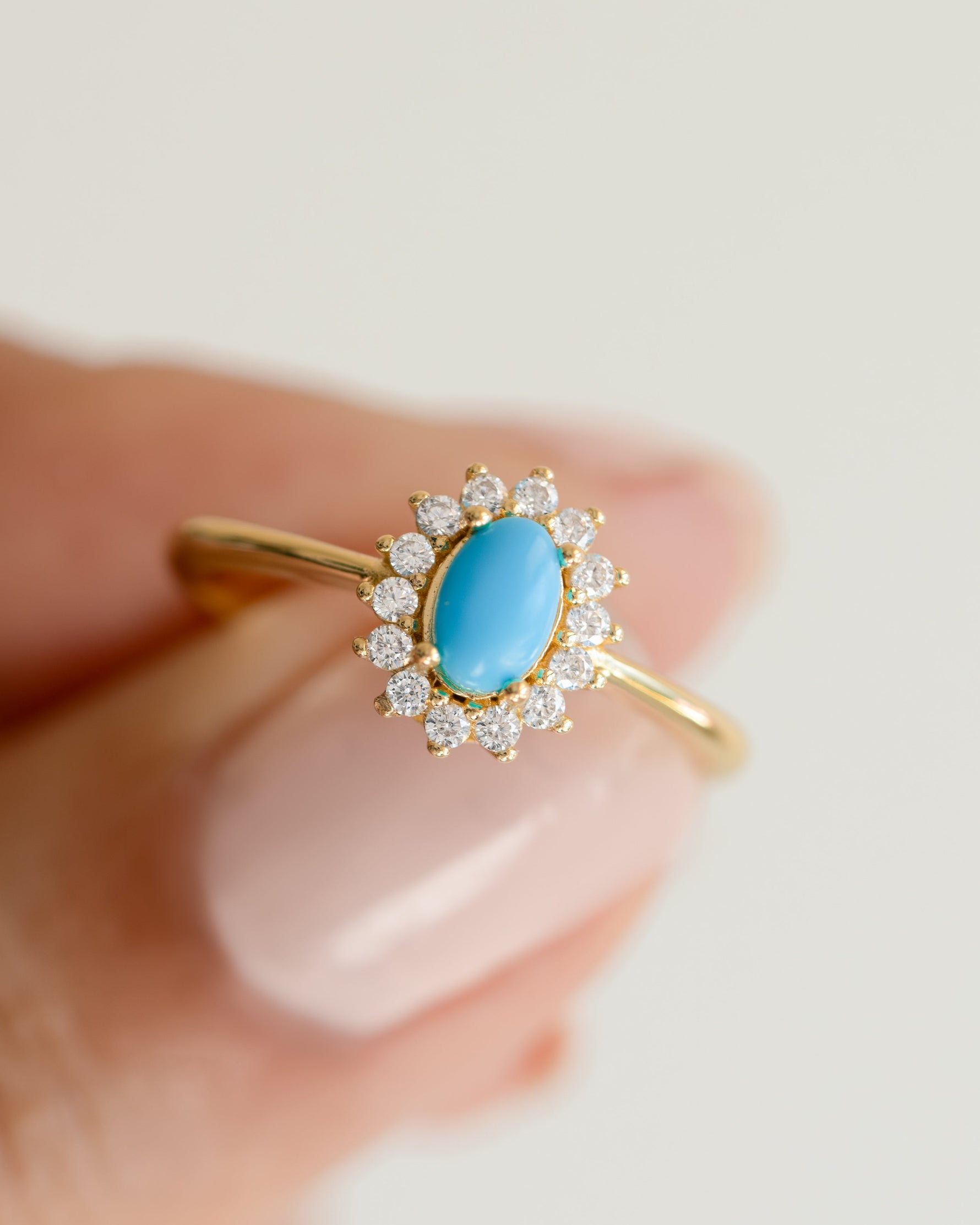 Close-up of Sami Jewels Layla Turquoise Ring featuring an oval turquoise gemstone with a gold halo setting.